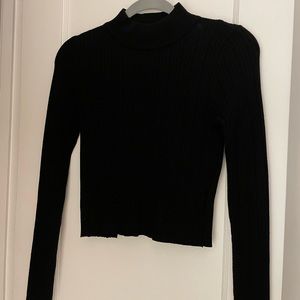 Vestique sweater with high neck and cut out back.
